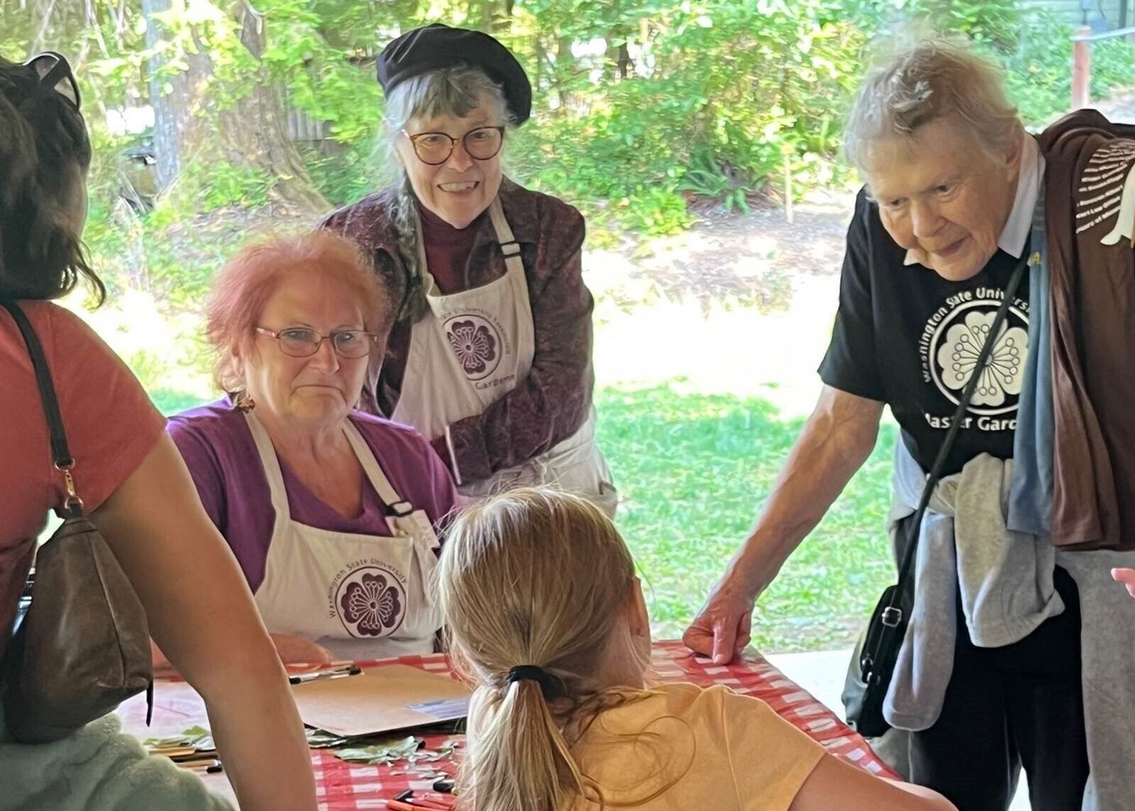 Master Gardeners helping youths with leaf rubbing at Fall Leaf Festival